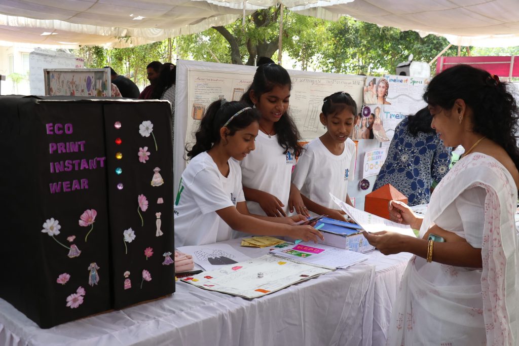 When children teach adults, an adolescent at Blue Blocks Montessori School, Hyderabad, explaining a student-designed project to a visitor at Explore Montessori 2025.