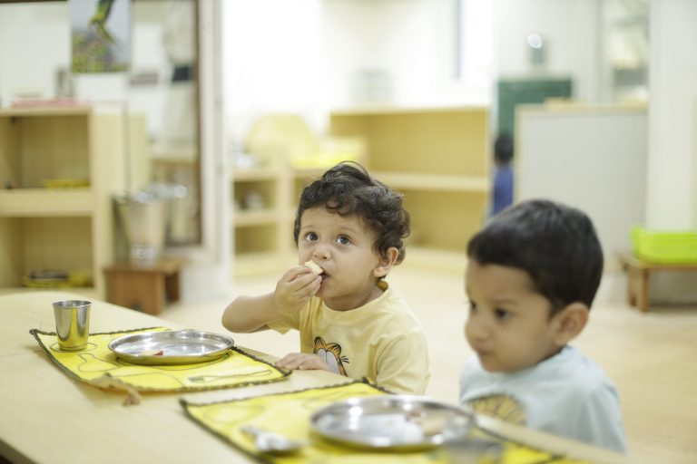 A toddler eating on their own, how to teach your toddler to eat by themselves through Montessori mealtime at Blue Blocks, Hyderabad