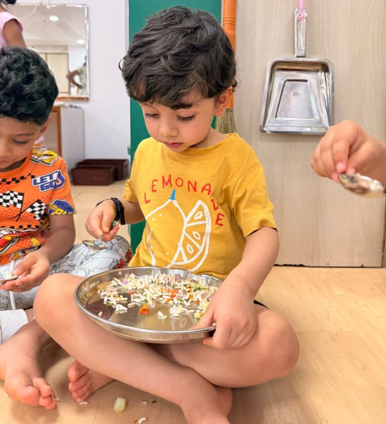A child learning mealtime at a shared table with real materials at child height — how to create a positive mealtime environment at Blue Blocks Montessori School, Hyderabad