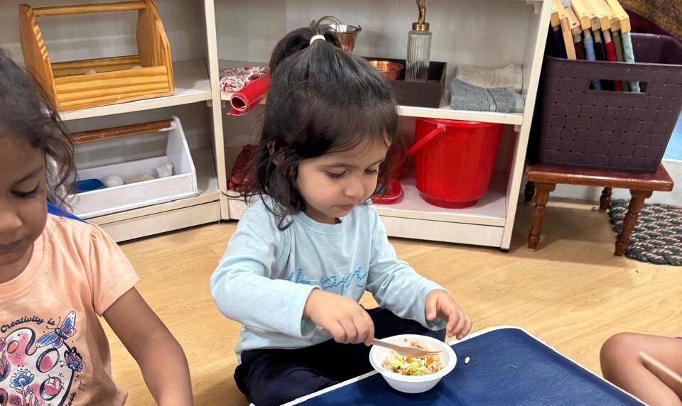 A child learning mealtime at a shared table with real materials at child height — how to create a positive mealtime environment at Blue Blocks Montessori School, Hyderabad