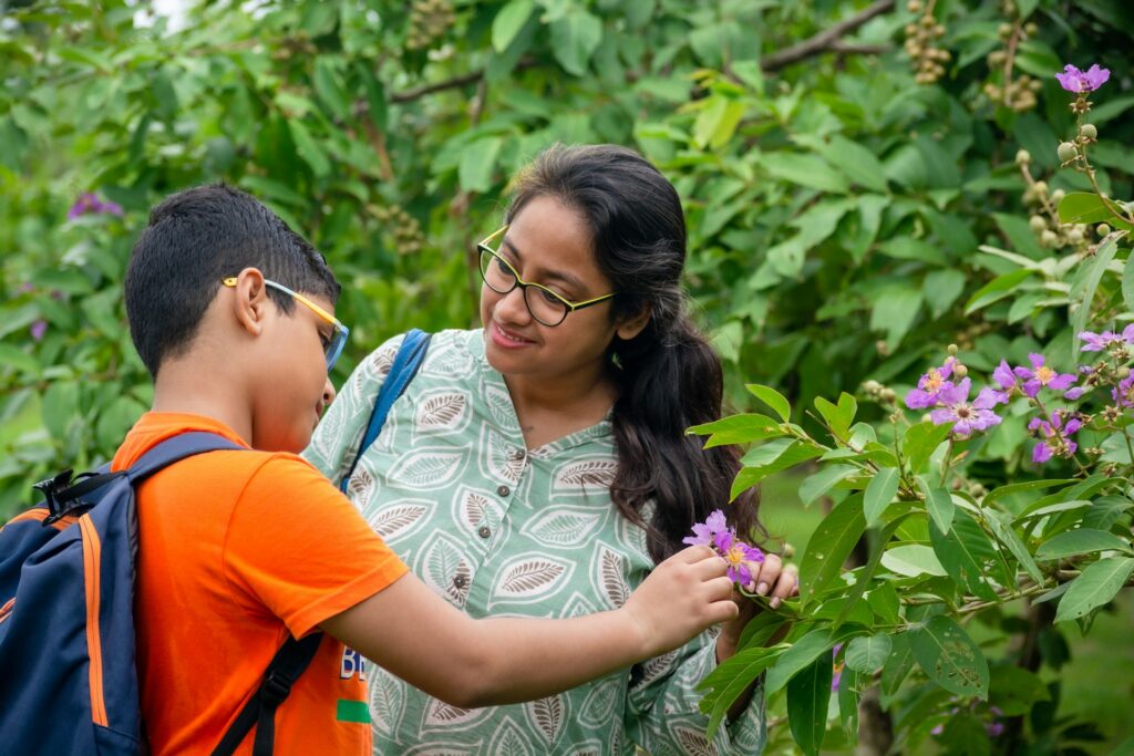 Child and parent in the garden, interacting with nature. How to keep children connected to nature through everyday home habits at Blue Blocks Montessori School, Hyderabad